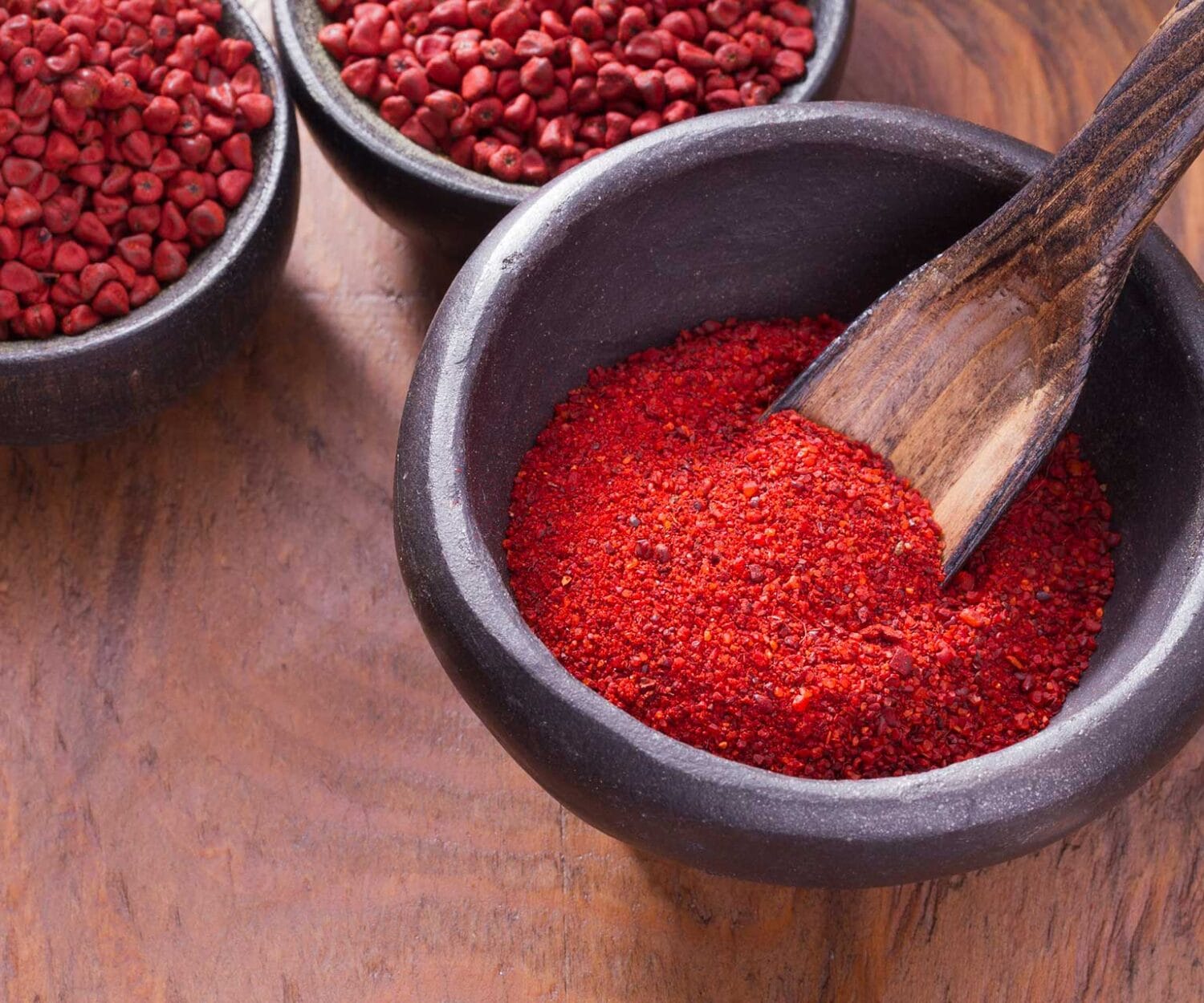 achiote in bowl on wooden background, achiote paste